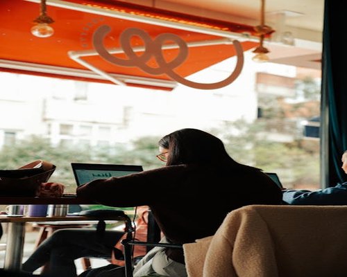 person working on laptop in sunny cafe by the window