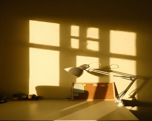 well lit minimal home office setup with desk lamp and window